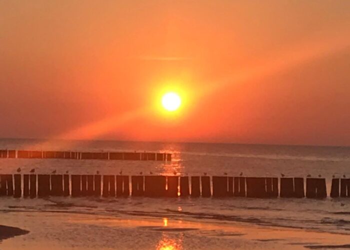 Sonnenuntergang über der Ostsee mit Spiegelung im Wasser.